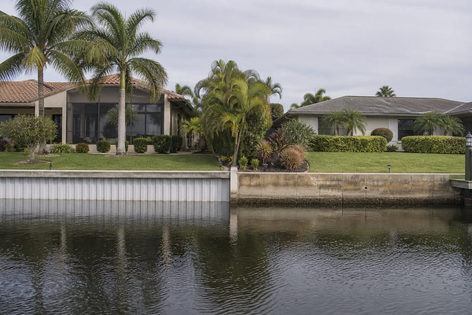 Illustration comparing neighboring waterfront properties with vinyl and concrete seawalls.