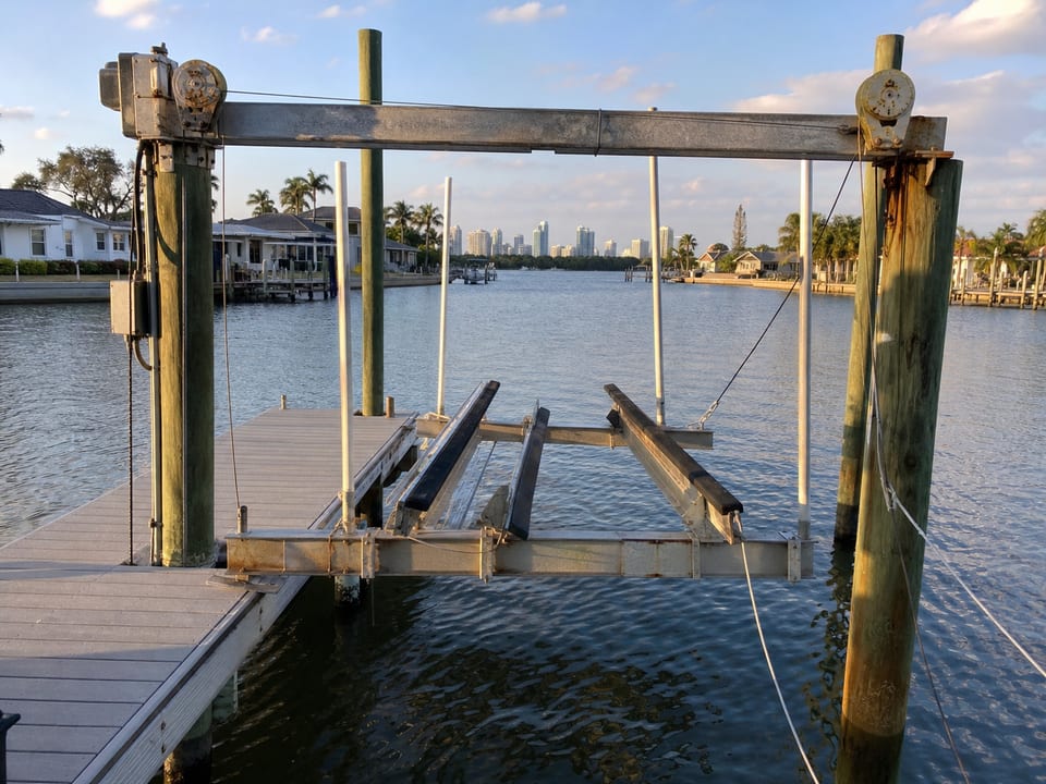 Illustration of an empty boat lift with uneven bunks, visible corrosion, and a slack cable.