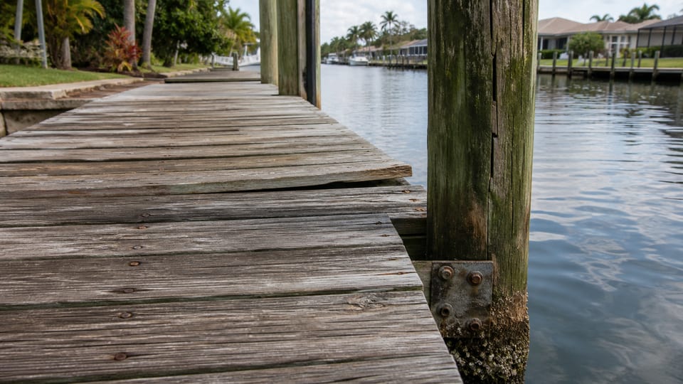 Illustration of a weathered dock with uneven boards, corroded fasteners, and worn pilings.